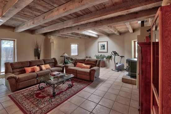 Large transitional formal open concept living room in Albuquerque with brown walls, ceramic floors, no fireplace, no tv and brown floor.