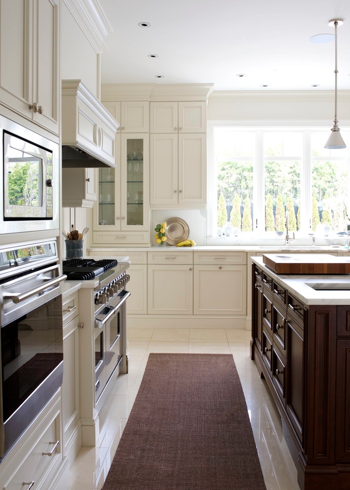 Foto på ett avskilt u-kök, med luckor med infälld panel, vita skåp, marmorbänkskiva, vitt stänkskydd, stänkskydd i sten, en köksö och rostfria vitvaror