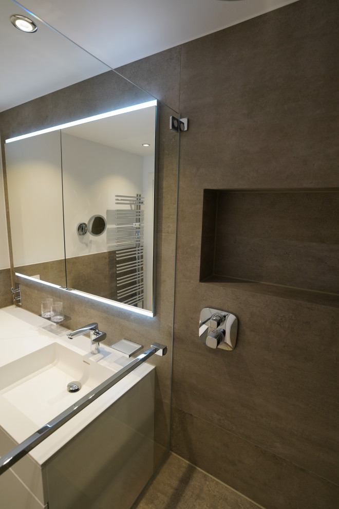 Свежая идея для дизайна: ванная комната среднего размера в стиле модернизм с плоскими фасадами, белыми фасадами, душем без бортиков, серой плиткой, каменной плиткой, белыми стенами, душевой кабиной, подвесной раковиной, столешницей из искусственного камня, душем с распашными дверями, белой столешницей, тумбой под одну раковину и подвесной тумбой - отличное фото интерьера