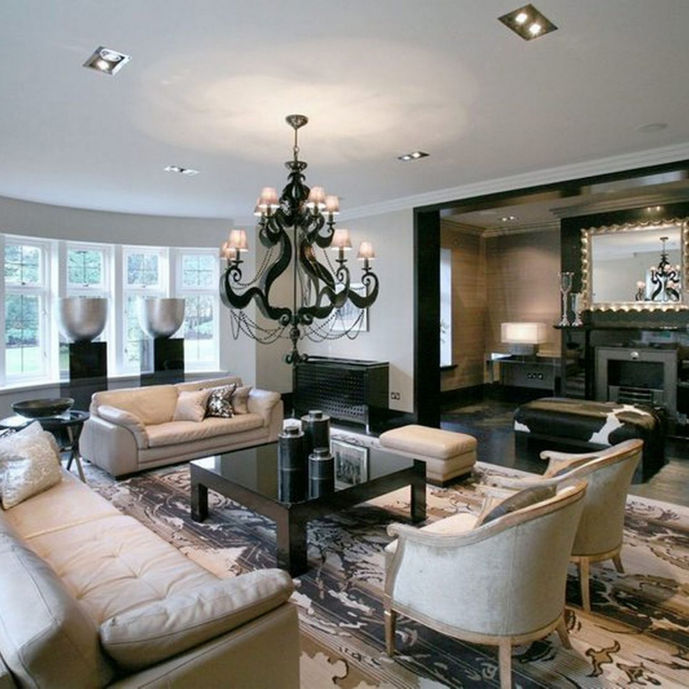 Photo of a large traditional formal open concept living room in Cheshire with beige walls, marble floors, a standard fireplace, a stone fireplace surround, a wall-mounted tv, black floor, vaulted and panelled walls.