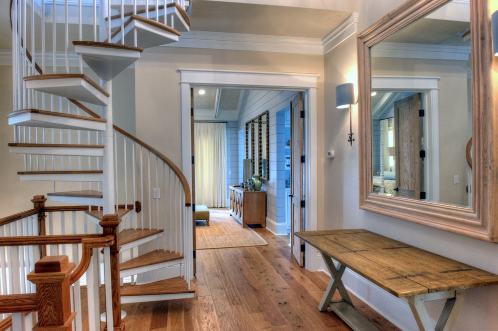 Photo of a mid-sized beach style hallway in Miami with beige walls and medium hardwood floors.