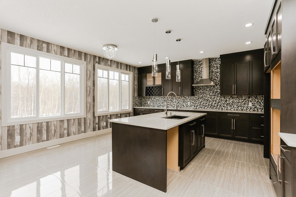 This is an example of a mid-sized transitional l-shaped separate kitchen in Edmonton with an undermount sink, shaker cabinets, black cabinets, quartz benchtops, multi-coloured splashback, mosaic tile splashback, stainless steel appliances, porcelain floors, with island, beige floor and white benchtop.