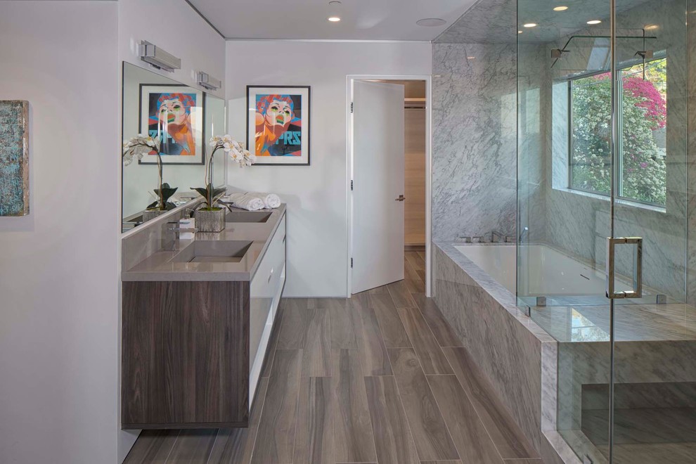 Design ideas for a large modern 3/4 bathroom in Los Angeles with flat-panel cabinets, white cabinets, a corner tub, an open shower, a one-piece toilet, gray tile, stone slab, white walls, dark hardwood floors, a drop-in sink, solid surface benchtops, brown floor and an open shower.