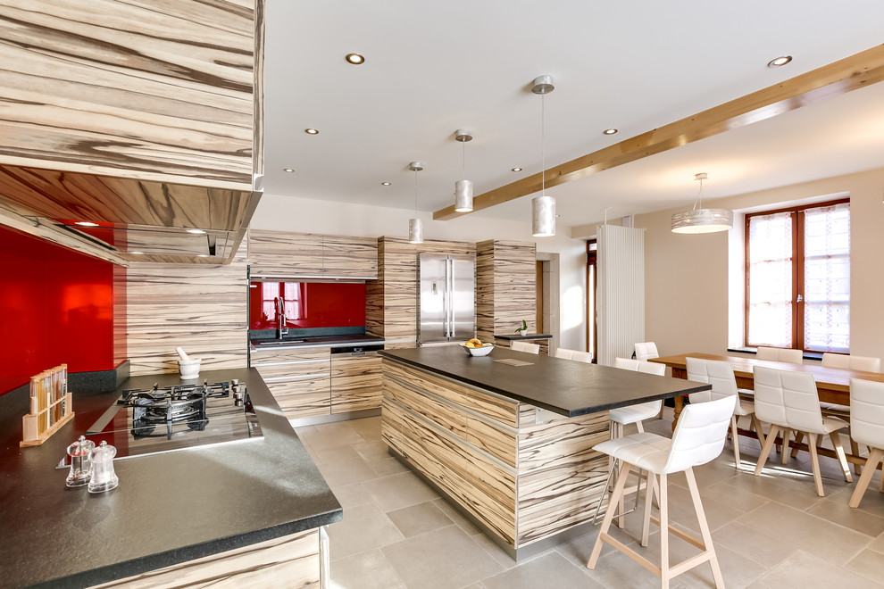 Inspiration for a large contemporary l-shaped eat-in kitchen in Lyon with an undermount sink, flat-panel cabinets, light wood cabinets, quartzite benchtops, red splashback, glass sheet splashback, stainless steel appliances, slate floors and with island.