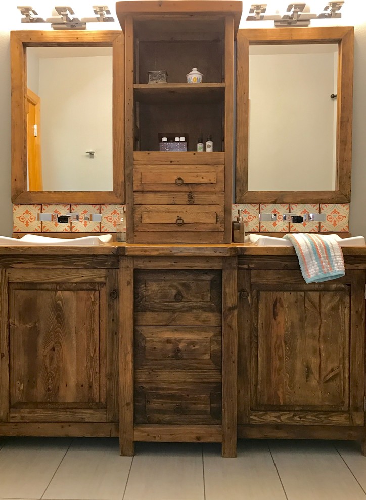 Inspiration for an eclectic bathroom in Seattle with furniture-like cabinets, dark wood cabinets, a drop-in tub, an alcove shower, a one-piece toilet, orange tile, terra-cotta tile, grey walls, porcelain floors, a drop-in sink, wood benchtops, grey floor and a shower curtain.