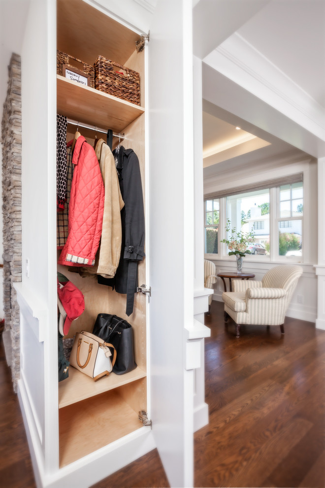 Photo of a small arts and crafts gender-neutral storage and wardrobe in San Francisco with raised-panel cabinets, white cabinets and dark hardwood floors.