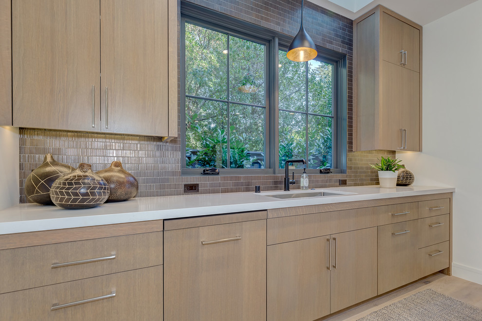 This is an example of a country kitchen in San Francisco with flat-panel cabinets, light wood cabinets, light hardwood floors and with island.