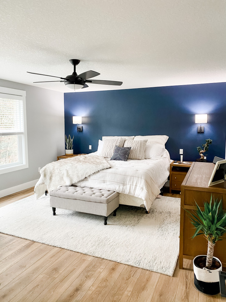 ポートランドにある広いコンテンポラリースタイルのおしゃれな主寝室 (青い壁、ラミネートの床、茶色い床)
