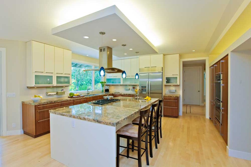 Design ideas for a large contemporary u-shaped open plan kitchen in San Francisco with an undermount sink, flat-panel cabinets, granite benchtops, white splashback, stainless steel appliances, light hardwood floors, white cabinets, with island, beige floor and multi-coloured benchtop.