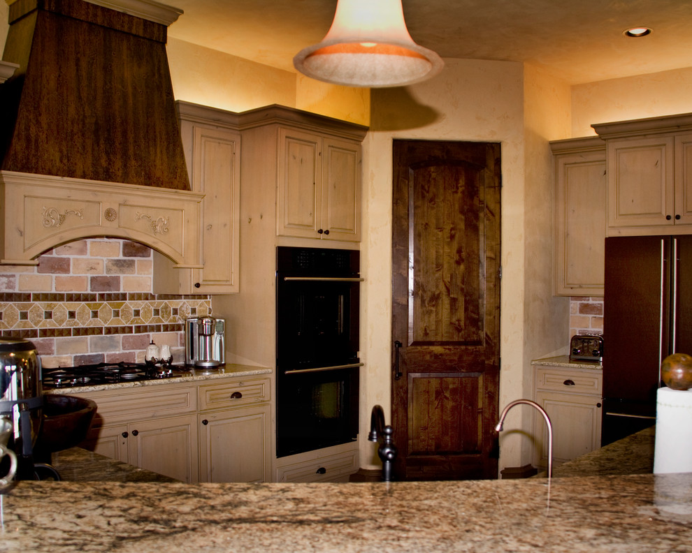 This is an example of a country eat-in kitchen in Austin with raised-panel cabinets, light wood cabinets, granite benchtops, beige splashback, stone tile splashback, brick floors and with island.