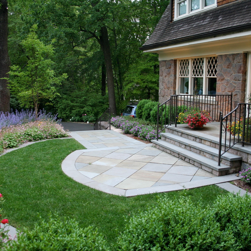 This is an example of a small traditional front yard full sun garden in New York with concrete pavers.
