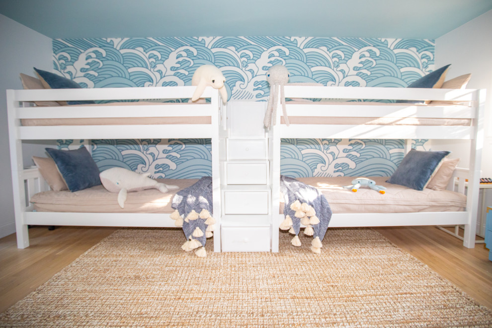 Aménagement d'une grande chambre d'enfant de 4 à 10 ans bord de mer avec un mur bleu, parquet clair et du papier peint.