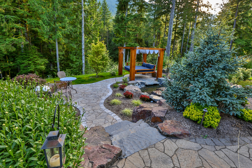 This is an example of a large traditional backyard garden in Seattle with concrete pavers and a garden path.