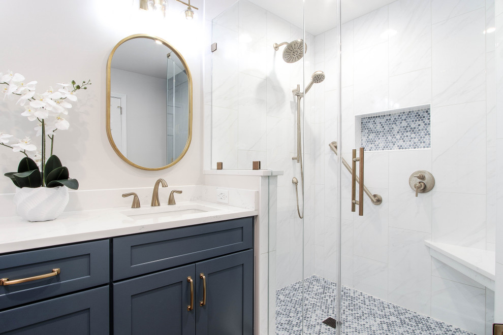 Example of a transitional 3/4 mosaic tile floor, blue floor and single-sink alcove shower design with shaker cabinets, blue cabinets, white walls, an undermount sink, a hinged shower door, white countertops, a niche and a built-in vanity