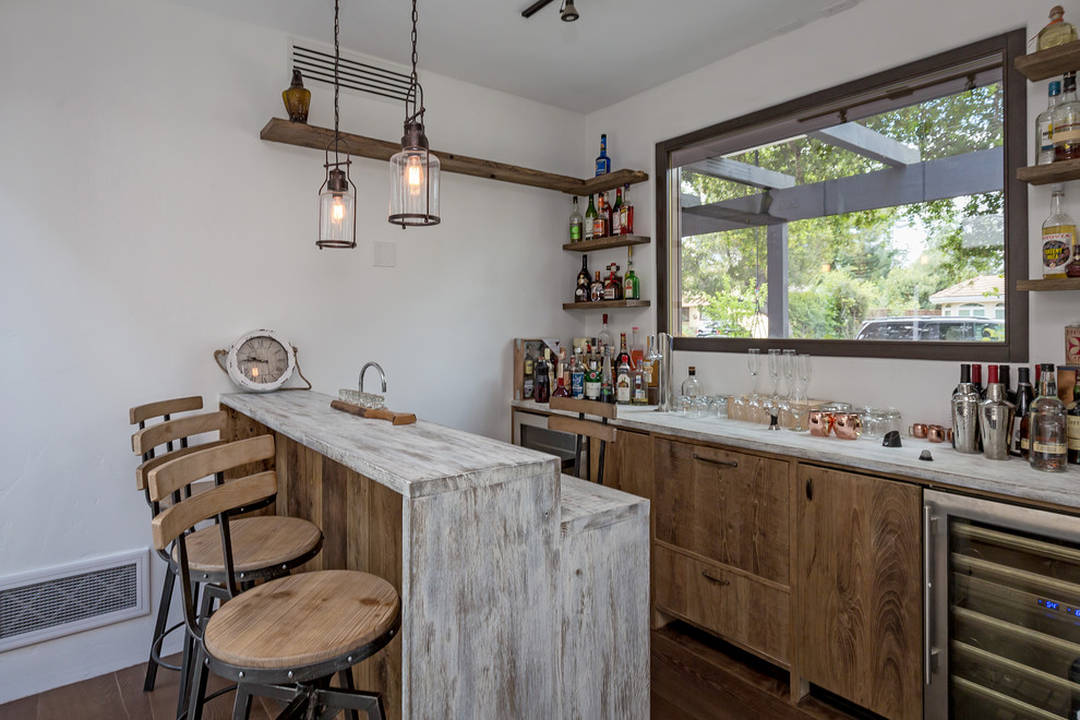 Photo of a mediterranean galley seated home bar in San Francisco with medium wood cabinets, dark hardwood floors, brown floor, wood benchtops and white benchtop.