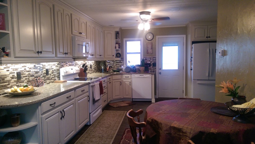 Mid-sized transitional l-shaped laminate floor eat-in kitchen photo with an undermount sink, raised-panel cabinets, white cabinets, granite countertops, multicolored backsplash, mosaic tile backsplash, white appliances and no island