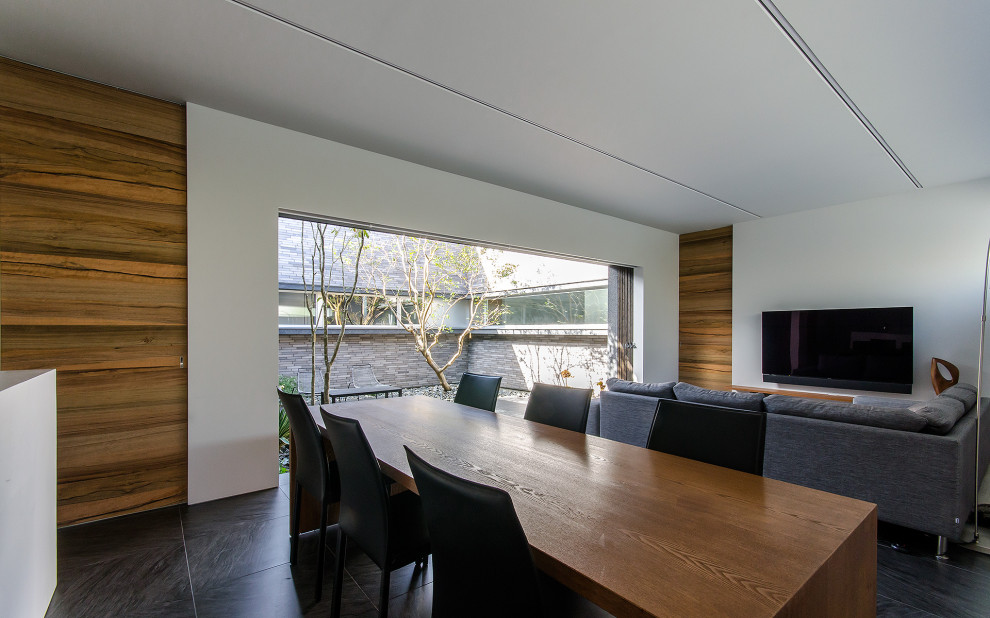 Idee per una sala da pranzo aperta verso il soggiorno minimalista di medie dimensioni con pareti bianche, pavimento con piastrelle in ceramica e pavimento nero