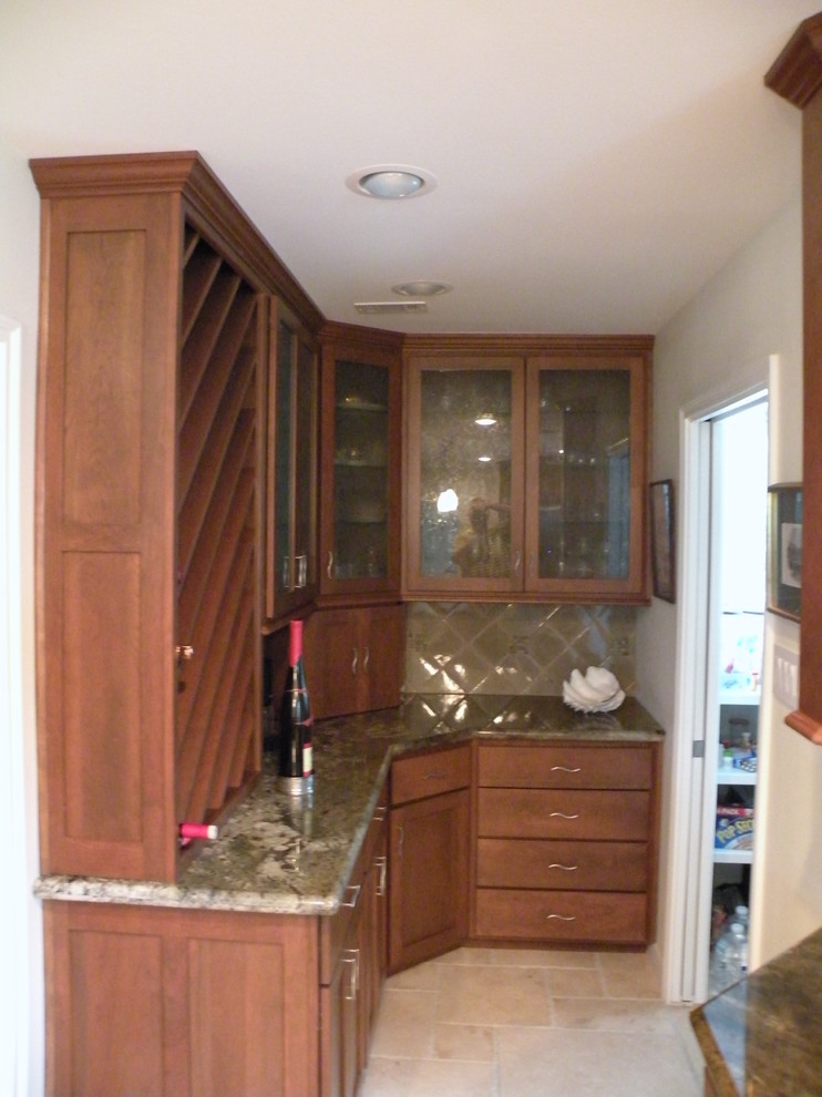 Example of a mid-sized transitional u-shaped limestone floor eat-in kitchen design in Houston with an undermount sink, shaker cabinets, medium tone wood cabinets, granite countertops, beige backsplash, ceramic backsplash, stainless steel appliances and an island