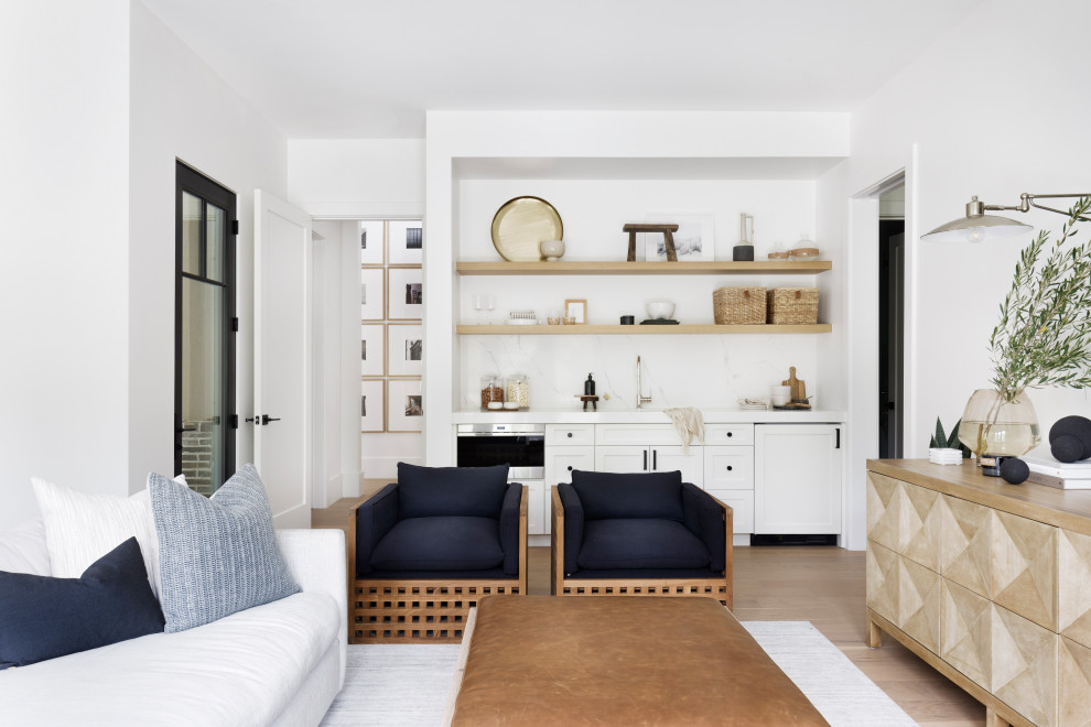 Exempel på ett stort klassiskt allrum med öppen planlösning, med en hemmabar, vita väggar, ljust trägolv, en väggmonterad TV och beiget golv