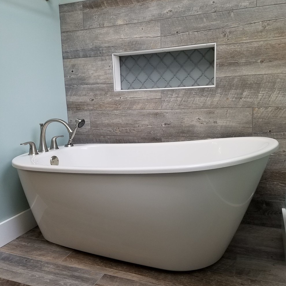 Example of a mid-sized transitional brown tile and porcelain tile medium tone wood floor and brown floor freestanding bathtub design with gray walls