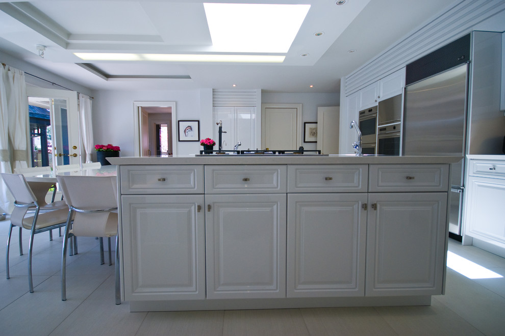 Eat-in kitchen - large transitional u-shaped marble floor eat-in kitchen idea in Toronto with a single-bowl sink, raised-panel cabinets, white cabinets, solid surface countertops, stainless steel appliances and a peninsula