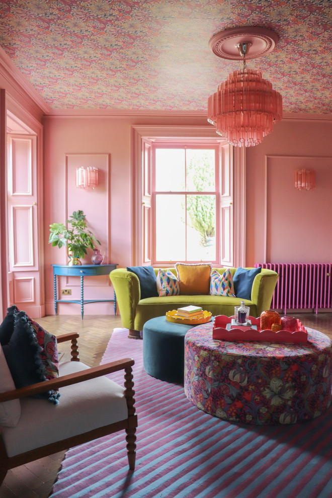 Eclectic living room with pink walls, medium hardwood flooring, brown floors, a wallpapered ceiling and panelled walls.