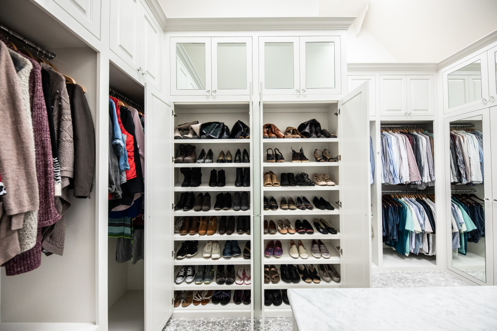 This is an example of a large classic gender neutral walk-in wardrobe in Dallas with beaded cabinets, white cabinets, carpet, grey floors and a vaulted ceiling.
