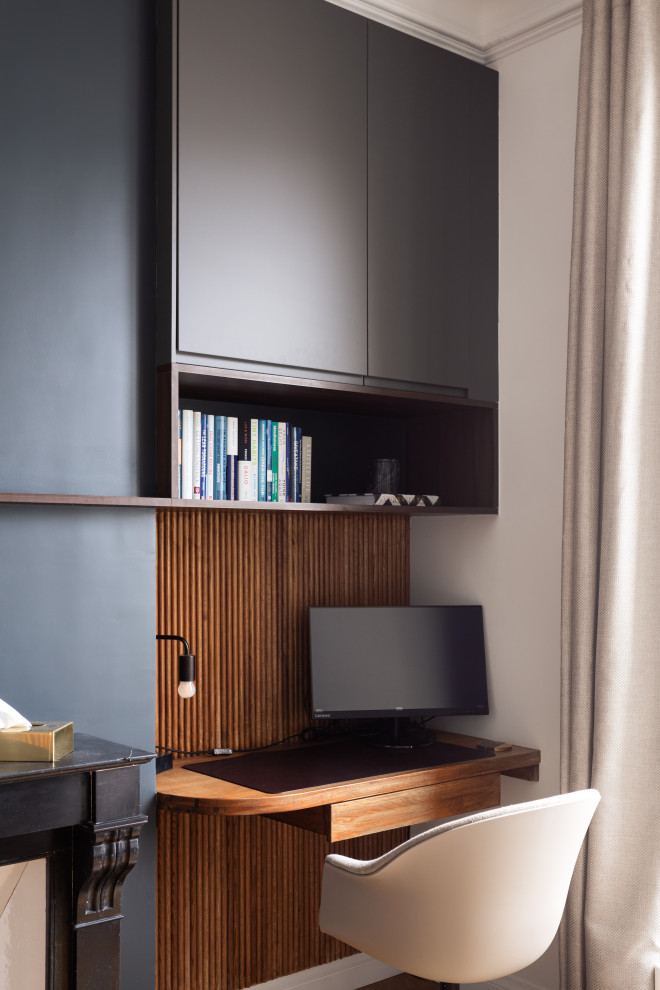 Cette photo montre un bureau moderne en bois de taille moyenne avec un mur noir, un sol en bois brun, une cheminée standard, un manteau de cheminée en pierre, un bureau intégré et un plafond en bois.