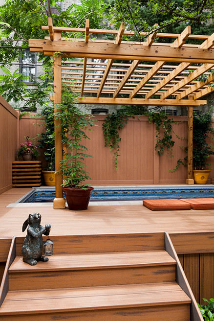 This is an example of a mid-sized traditional backyard rectangular aboveground pool in New York with a pool house and decking.