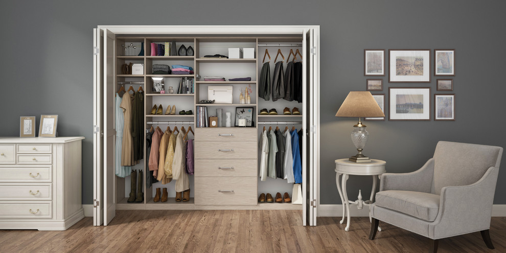 Inspiration for a mid-sized traditional gender-neutral built-in wardrobe in Nashville with flat-panel cabinets, light wood cabinets and medium hardwood floors.