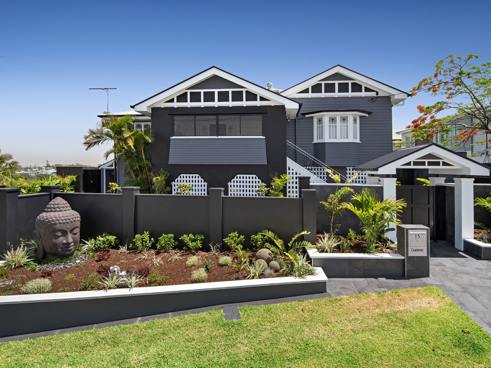Photo of a large transitional two-storey black house exterior in Brisbane with wood siding and a gable roof.