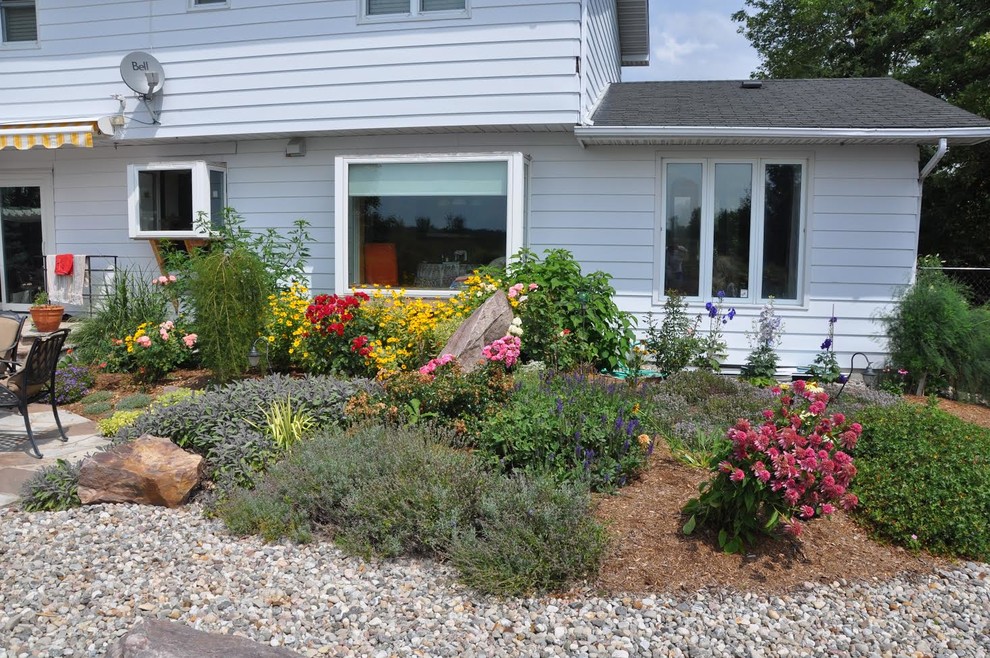 Design ideas for a large transitional backyard stone landscaping in Ottawa.