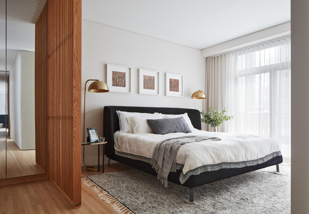 Ejemplo de dormitorio actual con suelo de madera clara