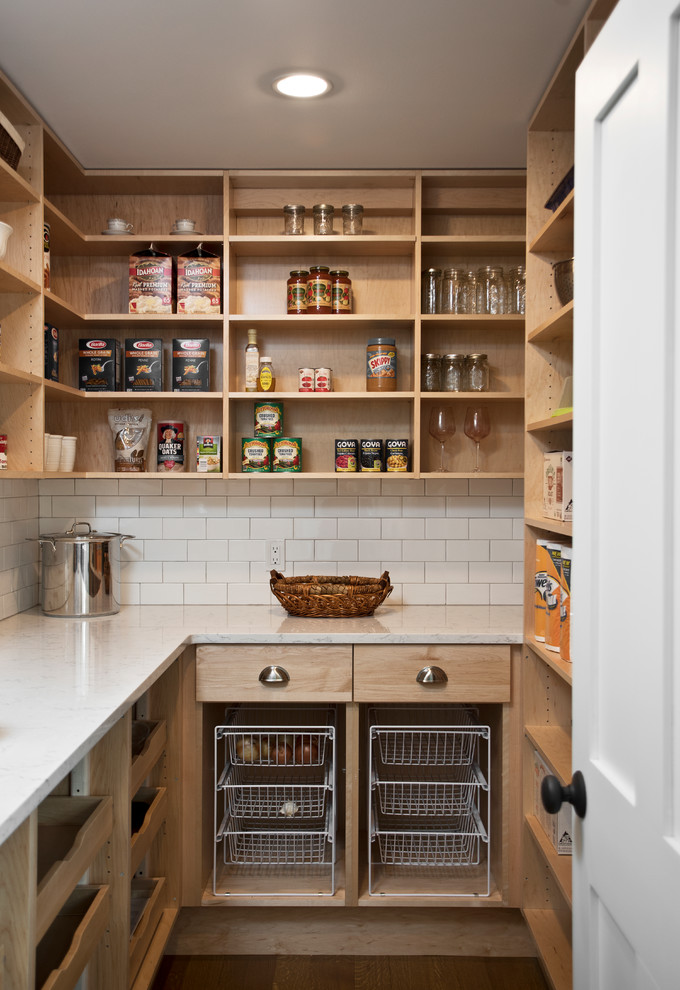 Design ideas for a mid-sized country u-shaped kitchen pantry in New York with flat-panel cabinets, medium wood cabinets, white splashback, subway tile splashback, dark hardwood floors, no island, brown floor and white benchtop.