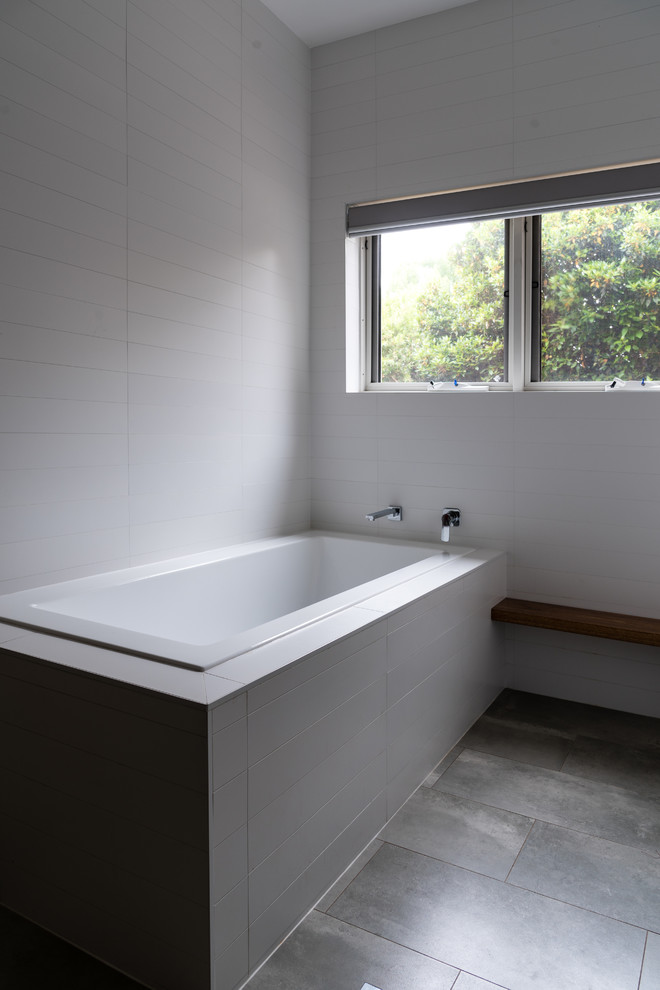 This is an example of a mid-sized modern master bathroom in Canberra - Queanbeyan with a drop-in tub, an open shower, a one-piece toilet, white tile, ceramic tile, white walls, cement tiles, a pedestal sink, terrazzo benchtops, grey floor and an open shower.