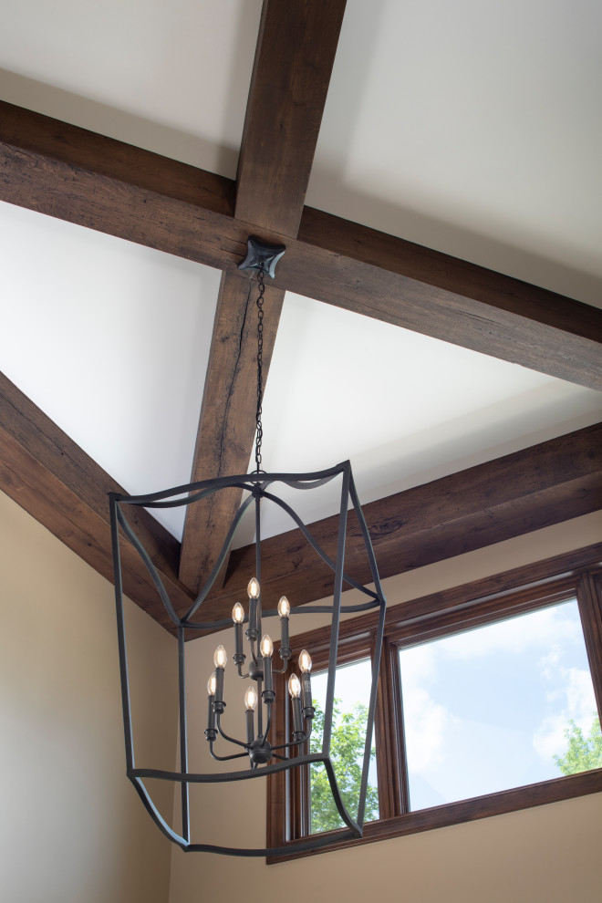 Example of a large mountain style vaulted ceiling entryway design in Minneapolis with a medium wood front door