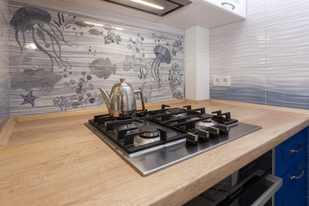 Идея дизайна: отдельная, параллельная кухня в морском стиле с фасадами с утопленной филенкой, синими фасадами и деревянной столешницей