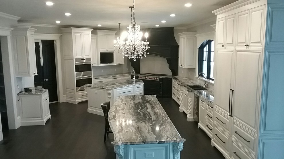 Design ideas for an expansive traditional l-shaped separate kitchen in Boston with raised-panel cabinets, white cabinets, quartzite benchtops, grey splashback, dark hardwood floors, multiple islands and black floor.
