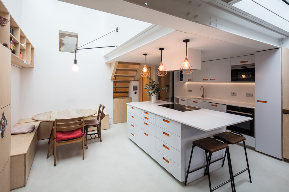 Scandinavian eat-in kitchen in London with an undermount sink, flat-panel cabinets, grey cabinets, white splashback, with island, grey floor and white benchtop.