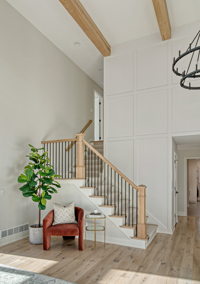 Large transitional foyer in Minneapolis with grey walls, medium hardwood floors, a single front door, brown floor, exposed beam and decorative wall panelling.
