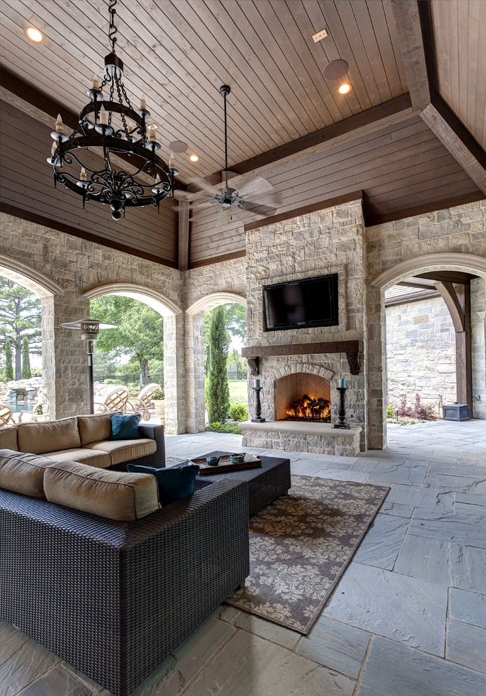 This is an example of a mediterranean verandah in Dallas with a fire feature and a roof extension.