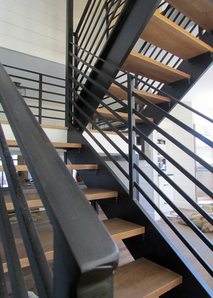 Design ideas for a large modern wood u-shaped staircase in Portland Maine with open risers.