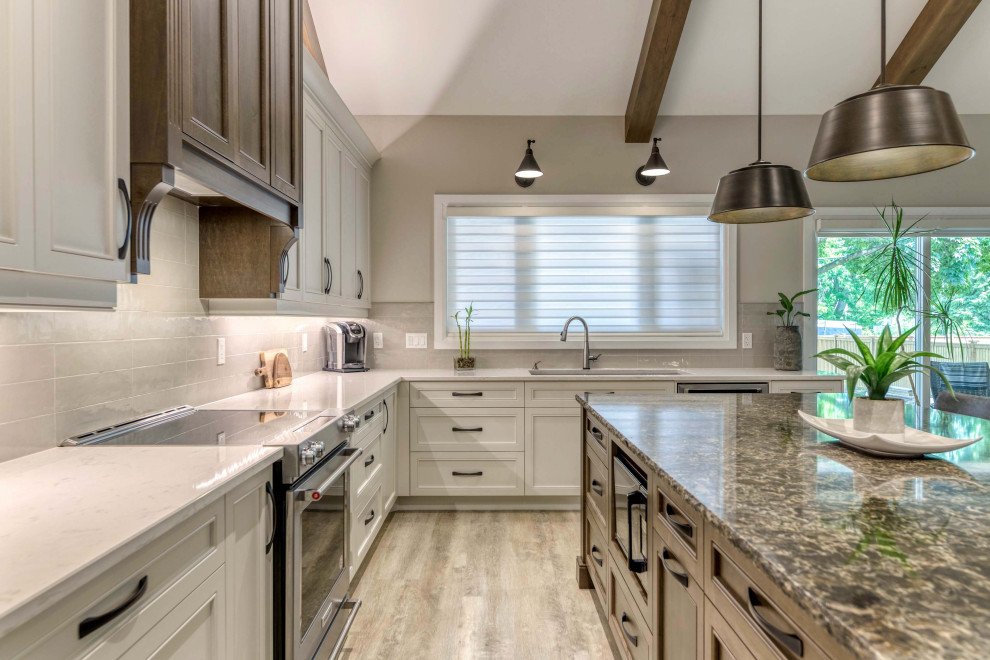 Example of a large transitional eat-in kitchen design with an undermount sink, shaker cabinets, quartz countertops, porcelain backsplash, stainless steel appliances and an island