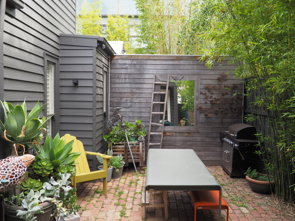 Photo of a small eclectic two-storey grey exterior in Melbourne with wood siding and a gable roof.