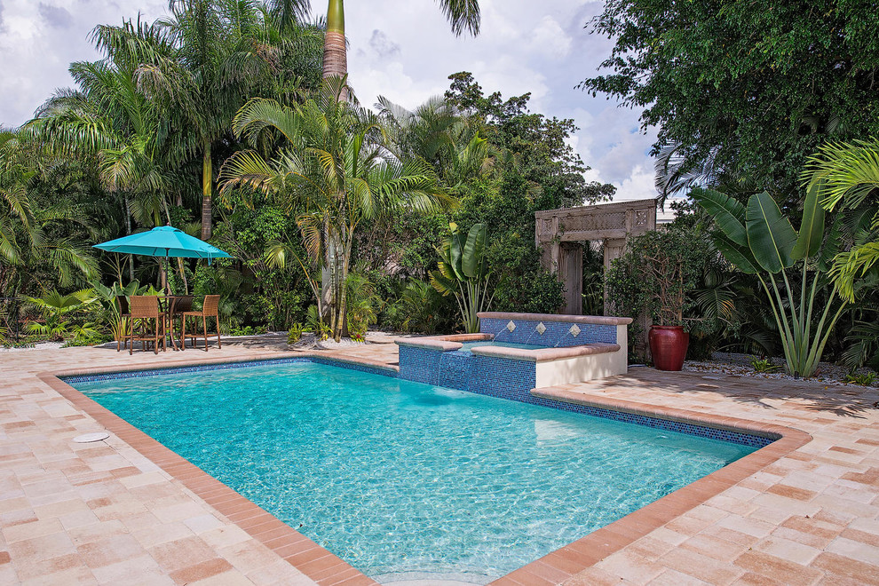 Tropical pool in Miami with brick pavers.