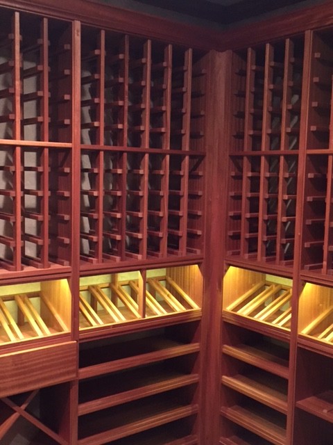 Photo of a mid-sized country wine cellar in Other with medium hardwood floors, diamond bins and brown floor.