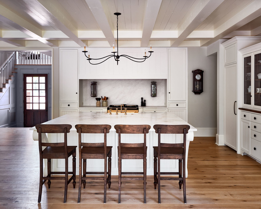 Mid-sized traditional galley eat-in kitchen in Charlotte with white cabinets, with island, white splashback, panelled appliances, medium hardwood floors, a farmhouse sink, flat-panel cabinets, marble benchtops and stone slab splashback.