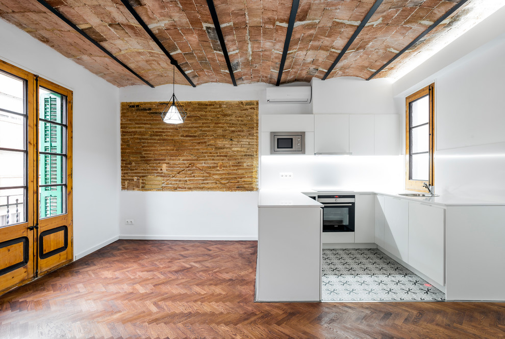 Mid-sized mediterranean kitchen in Barcelona with medium hardwood floors and brown floor.