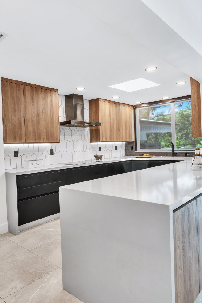 Example of a mid-sized mid-century modern u-shaped porcelain tile and gray floor kitchen design in Miami with an undermount sink, flat-panel cabinets, black cabinets, quartz countertops, white backsplash, stone tile backsplash, paneled appliances, a peninsula and gray countertops
