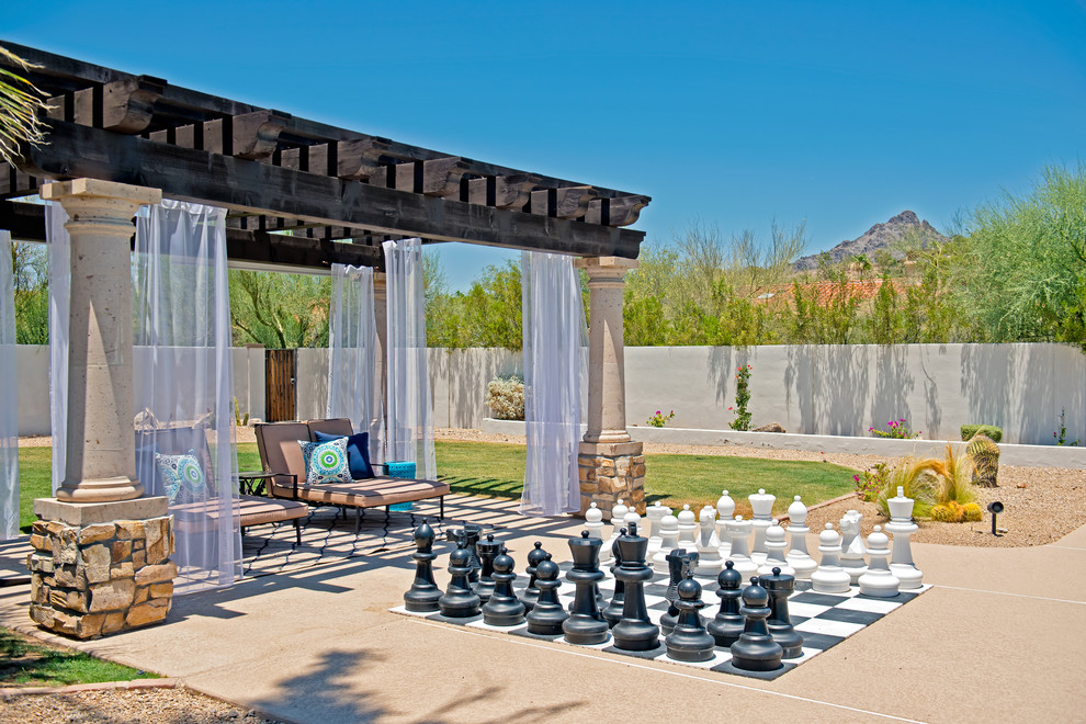 This is an example of an expansive transitional backyard patio in Phoenix with a pergola.
